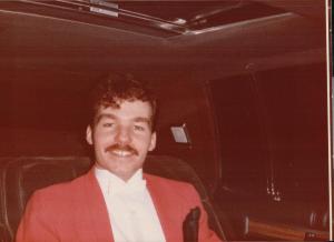 John's snazzy red dinner jacket and new haircut.